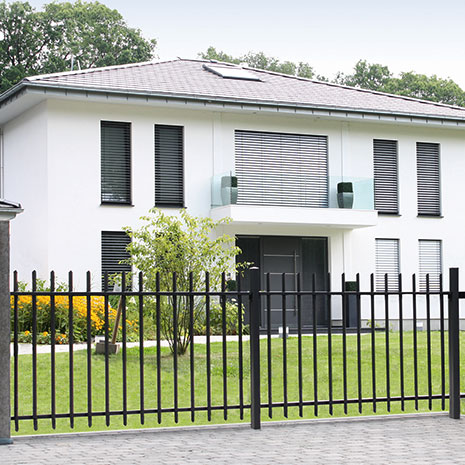 Ein modernes Haus mit Gartengrundstück und einem anthraziten Zaunelement im Vordergrund